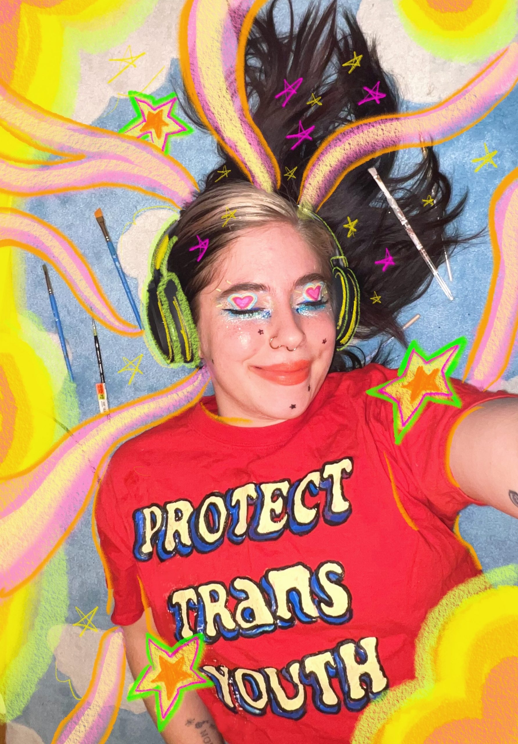 photo of Rhiannon, a white nonbinary person with colorful makeup and a red Protect Trans Youth shirt