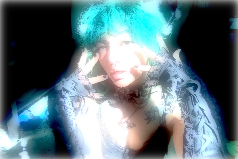 an over exposed photo of wsteaway, a white nonbinary person with an alternative aesthetic and bright teal hair