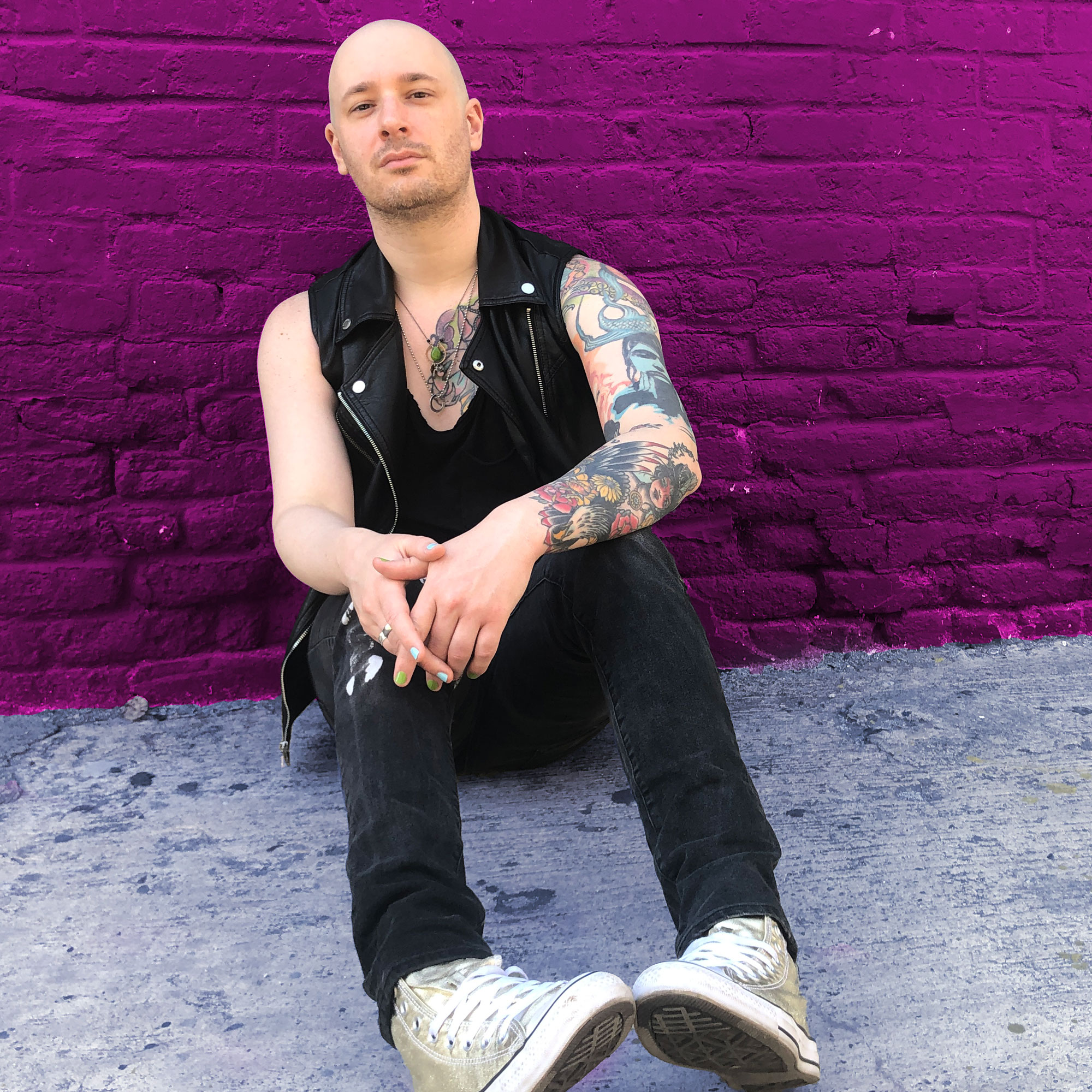 photo of VATTICA, a white nonbinary person with no hair, tattoos, and a leather vest