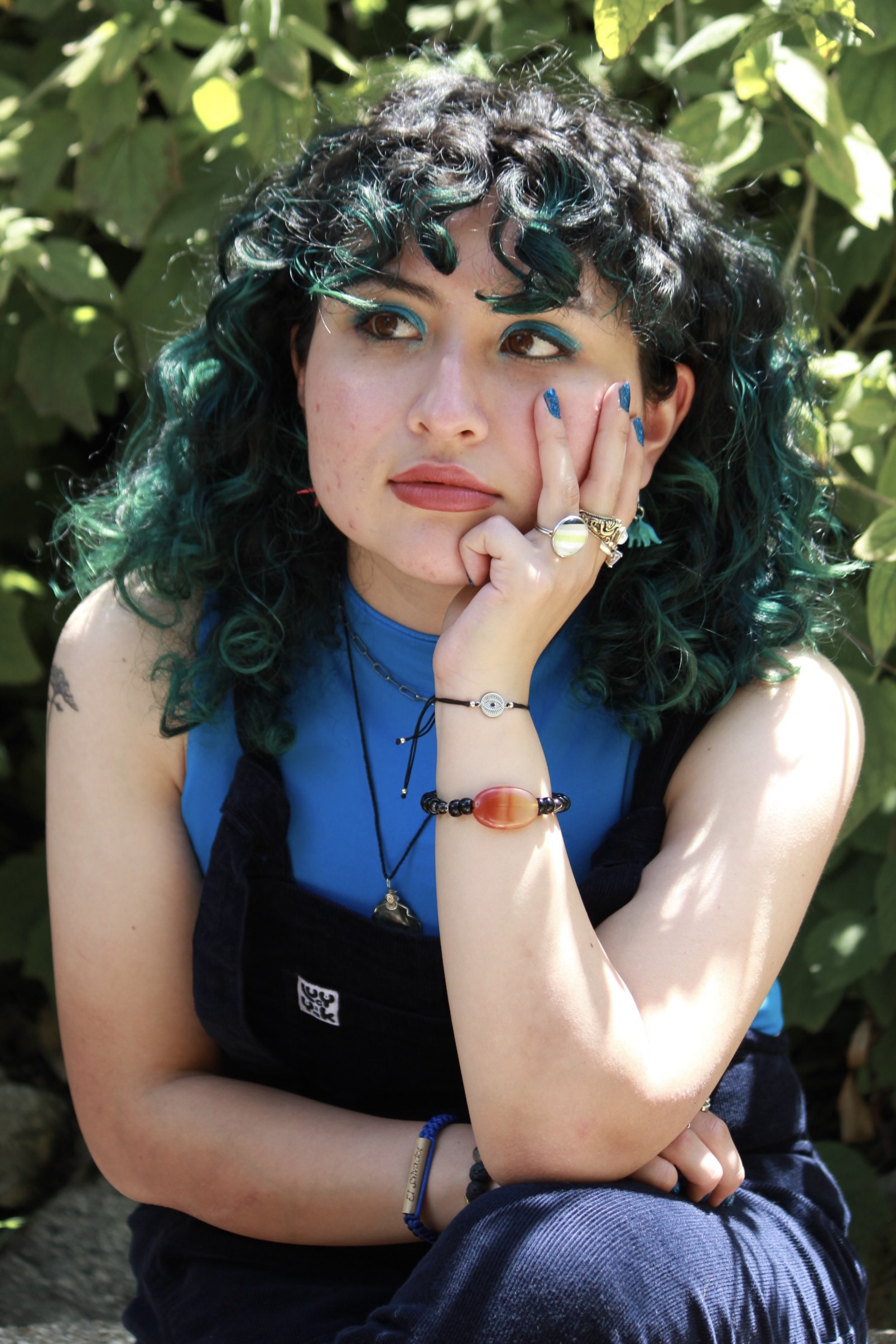 photo of lorely, an agender person with curly black hair and a blue outfit